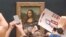 Yon gad sekirite netwaye krem gato ki kouvri vit tablo Mona Lisa a nan mize Louvre la nan vil Paris an Frans, 29 Me, 2022. 