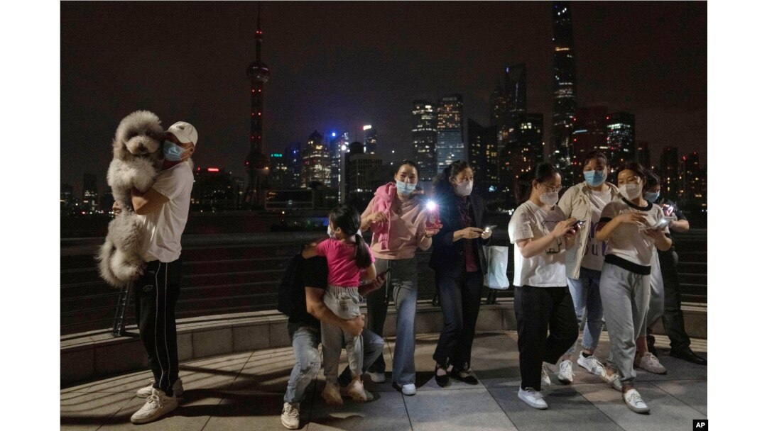 Warga berkumpul untuk berfoto saat mendekati tengah malam pada malam pencabutan lockdown COVID-19, Selasa, 31 Mei 2022, di Shanghai. (Foto: AP)