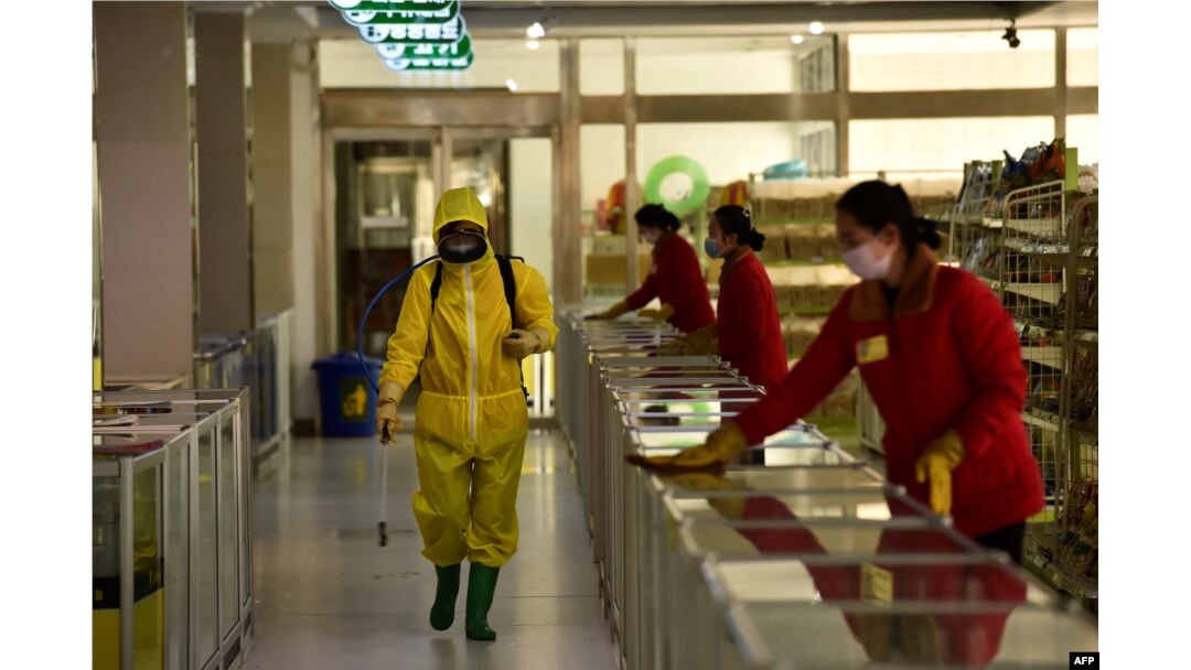 Karyawan menyemprotkan disinfektan di Pyongyang. (Foto: AFP)