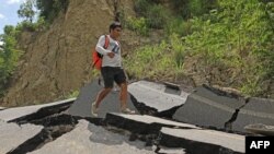 Seorang pria berjalan di area jalanan yang rusak akibat gempa berkekuatan 7.5 yang menyerang wilayah utara Peru pada 29 November 2021. (Foto: Peruvian Presidency/AFP/Aldair Mejia)