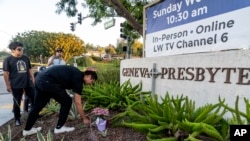 Hector Gomez, left, and Jordi Poblete, worship leaders at the Mariners Church Irvine, leave flowers outside the Geneva Presbyterian Church in Laguna Woods, Calif., May 15, 2022, after a fatal shooting.
