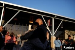 Orang-orang berpelukan sehari setelah seorang pria bersenjata membunuh 19 anak dan dua guru di Sekolah Dasar Robb, di Uvalde County Fairplex Arena, di Uvalde, Texas, AS, 25 Mei 2022. (Foto: Reuters)