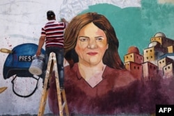 FILE - Palestinian artists paint a mural in honor of slain veteran Al-Jazeera journalist Shireen Abu Akleh in Gaza City. Abu Akleh was shot dead on May 11, 2022, while covering a raid in the Israeli-occupied West Bank.