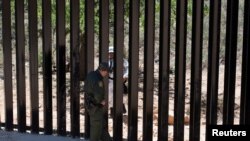 US Customs and Border Protection supervisory agent Carlos Ruiz, left, speaks with a member of the Mexico national guard performing a mirror patrol near Sasabe, Arizona, May 10, 2022.