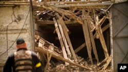 A Ukrainian policeman checks the wreckage in a heavily damaged sunflower seed processing plant after a Russian bombing in Velyka Kostromka village, Ukraine, May 19, 2022. 