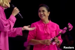 Philippine Vice President and presidential candidate Leni Robredo holds pink flowers during her "Miting de Avance" rally in Makati City, Metro Manila, May 7, 2022.