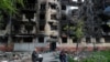 A local resident walks past a building heavily damaged during the Ukraine-Russia conflict in the southern port city of Mariupol, Ukraine, May 20, 2022.