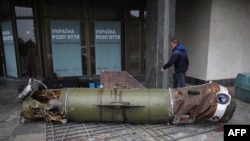 A visitor walks past the remains of a missile from the recent Ukraine Russia conflict, at the entrance to the World War II open-air museum in Kyiv on May 8, 2022, a day before 'Victory Day' is commemorated in Ukraine. 