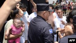 Las personas detenidas por presuntos vínculos con pandillas son escoltadas por la Policía Nacional Civil durante el estado de emergencia declarado por el gobierno salvadoreño en el centro penal de San Salvador, el 25 de abril de 2022.
