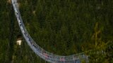 Visitors cross a suspension bridge for pedestrians that is the longest such construction in the world shortly after its official opening at a mountain resort in Dolni Morava, Czech Republic.