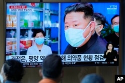 FILE - People watch a TV screen showing a news program reporting with an image of North Korean leader Kim Jong Un, at a train station in Seoul, South Korea, May 16, 2022.