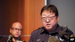 Dallas Police senior corporal Soo Kim addresses reporters in Korean as police Chief Eddie Garcia, left, looks on during a news conference at police headquarters headquarters in Dallas, May 17, 2022. Photo by AP