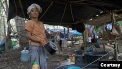 Internally displaced person Khaw Mying cleans a cooking pot near her temporary hut on the Thai-Myanmar border. (Steve Sandford/Asiareports) 