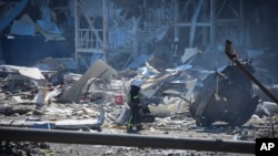 Украинский пожарный возле разрушенного здания на окраине Одессы. 10 мая 2022 г. 