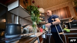 Daviti Suleimanishvili makes a coffee while staying in a friend's flat in Kyiv on May 24, 2022.