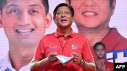 Philippine presidential candidate Ferdinand Marcos Jr. delivers a speech prior to introducing his son Ferdinand Alexander "Sandro" Marcos (back right) during a rally in Laoag, Ilocos Norte province, north of Manila, March 25, 2022.