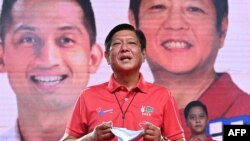Philippine presidential candidate Ferdinand Marcos Jr. delivers a speech prior to introducing his son Ferdinand Alexander "Sandro" Marcos (back R) during a rally in Laoag, Ilocos Norte province, north of Manila, March 25, 2022.