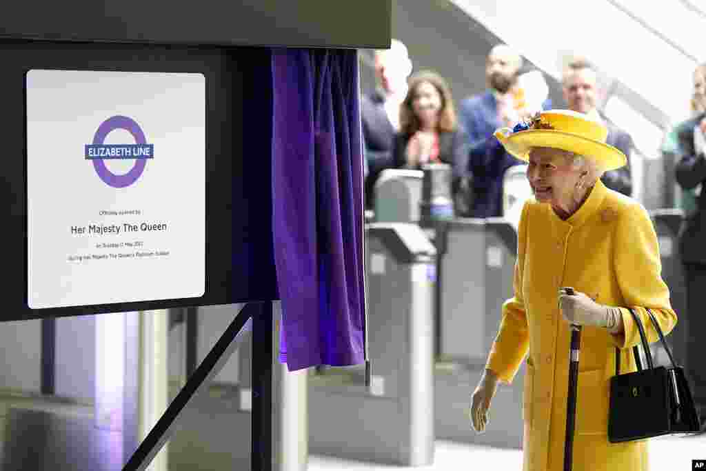 Britain&#39;s Queen Elizabeth II unveils a sign to mark the Elizabeth line&#39;s official opening at Paddington station in London.