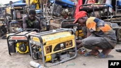 FILE - Workers repair generators at a workshop in the Bulabulin area of Maiduguri, Nigeria, Feb. 1, 2021. Maiduguri residents struggled without electricity after IS-linked jihadists blew up supply lines.