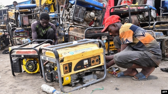 FILE - Workers repair generators at a workshop in the Bulabulin area of Maiduguri, Nigeria, Feb. 1, 2021. Maiduguri residents struggled without electricity after IS-linked jihadists blew up supply lines.