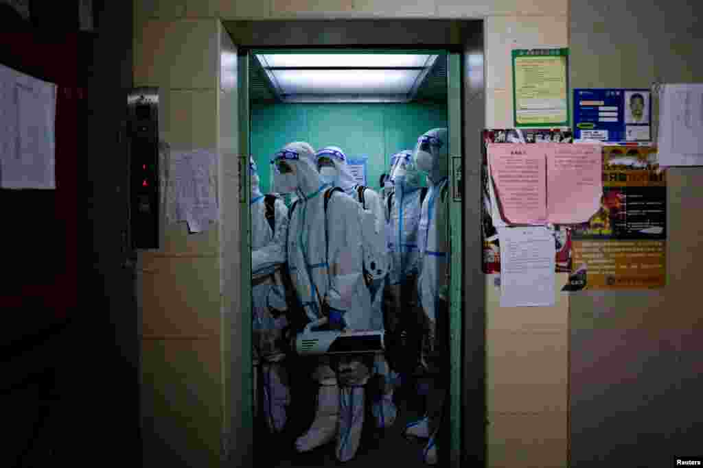 Workers in protective suits take an elevator as they disinfect a residential area during lockdown, amid the COVID-19 pandemic, in Shanghai, China.