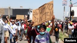 FILE - Students hold placards outside a school after allegations of racism in Randfontein, South Africa,. Taken February 14, 2022. 