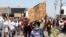 FILE - Students hold placards outside a school after allegations of racism in Randfontein, South Africa, February 14, 2022. 