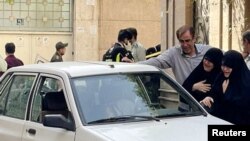 Family members of Colonel Sayad Khodai, a member of Iran's Islamic Revolution Guards Corps, weep over his body in his car after he was reportedly shot by two assailants in Tehran, Iran, May 22, 2022. (Handout via Reuters)