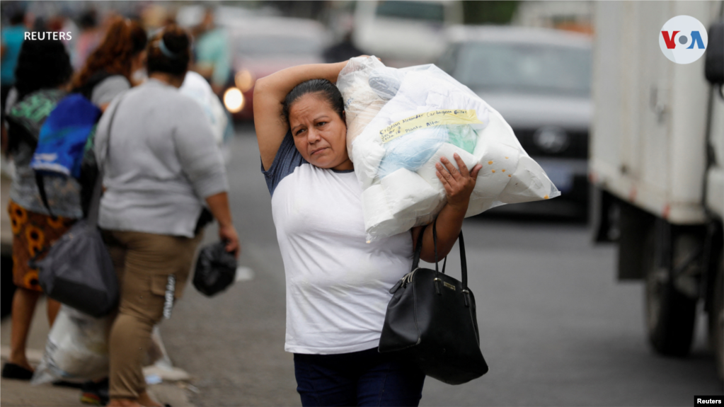 Una mujer carga un paquete con víveres para un familiar que fue detenido durante el estado de emergencia y que está en la cárcel La Esperanza.