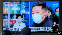 FILE - People in Seoul, South Korea, watch a TV showing North Korean leader Kim Jong Un, on May 16, 2022, as an illness suspected to be COVID-19 sickens hundreds of thousands of North Koreans.