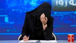 TV voditeljica Katere Ahmadi spušta glavu dok čita vijesti na stanici Tolo News u Kabulu, 22. maja 2022, nakon što su talibanski vladari odlučili da sve voditeljke na televiziji moraju da pokriju lice dok su u programu.