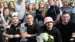 File - Oleh Psiuk, second from right, frontman of Ukraine's Kalush Orchestra, winners of the Eurovision Song Contest, and his band pose with the trophy in Krakovets, at the Ukraine border with Poland, Monday, May 16, 2022. On Sunday, they sold the crystal trophy to raise funds for the Ukrainian military fighting the Russian invasion of Ukraine.