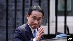 Japanese Prime Minister Fumio Kishida waves at the media as he leaves after his meeting with British Prime Minister Boris Johnson, at 10 Downing Street in London, May 5, 2022.