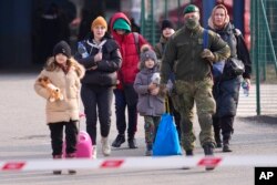 FILE - People fleeing from Ukraine cross the border in Vysne Nemecke, Slovakia, March 4, 2022.