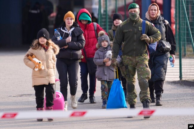 FILE - People fleeing from Ukraine cross the border in Vysne Nemecke, Slovakia, March 4, 2022.