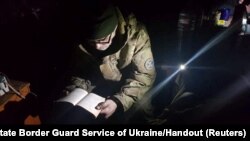 A service member of Mariupol's unit of the Ukrainian Sea Guard reads inside a bunker of the Azovstal Iron and Steel Works in Mariupol, Ukraine, in this handout picture released on May 15, 2022.