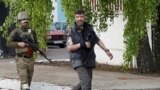 A wounded service member of Ukrainian forces who had surrendered after weeks holed up at Azovstal steel works is escorted by a member of the pro-Russian military at a detention facility in the settlement of Olenivka in the Donetsk Region, Ukraine, May 17,