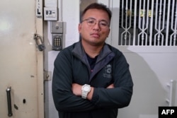 FILE - Ronson Chan, chair of the Hong Kong Journalist Association, posing outside the office of his former employer Stand News, which was shut down after police raided their offices and arrested seven people in Hong Kong, Jan. 7, 2022.