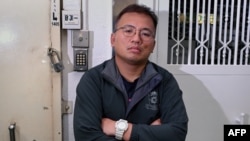 FILE - Ronson Chan, chair of the Hong Kong Journalist Association, poses outside his former employer Stand News, which was shut down after a police raid in Hong Kong, Jan. 7, 2022. Chan is on bail after being arrested Sept. 7, 2022, while on assignment in the Mongkok district.