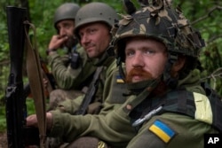 Ukrainian servicemen take rest in a recently retaken village north of Kharkiv, east Ukraine, May 15, 2022