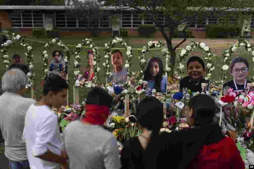 Pessoas reúnem-se num memorial na Escola Primária Robb em Uvalde, Texas, a 30 de Maio de 2022, para prestar a sua homenagem às vítimas mortas no tiroteio da semana anterior na escola.