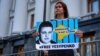 Kateryna Yesypenko se manifiesta con un cartel con el rostro de su esposo cerca de la oficina del presidente en Kiev en julio de 2021.