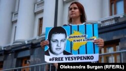 Kateryna Yesypenko se manifiesta con un cartel con el rostro de su esposo cerca de la oficina del presidente en Kiev en julio de 2021.