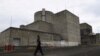 FILE - This photo taken on April 5, 2022 shows a security guard walking in front of the main gate of the Bataan Nuclear Power Plant in the town of Morong in Bataan province, north of Manila.