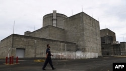 FILE - This photo taken on April 5, 2022 shows a security guard walking in front of the main gate of the Bataan Nuclear Power Plant in the town of Morong in Bataan province, north of Manila.