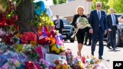 El presidente Joe Biden y la primera dama Jill Biden presentan sus respetos a las víctimas del tiroteo del sábado en un monumento al otro lado de la calle del TOPS Market en Buffalo, NY, 17 de mayo de 2022.