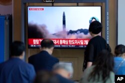Orang-orang menonton layar TV yang menampilkan program berita yang melaporkan peluncuran rudal Korea Utara di sebuah stasiun kereta api di Seoul, Korea Selatan, , 25 Mei 2022. (Foto: AP)