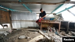 A man sits on a desk next to debris at his house damaged in the aftermath of Hurricane Agatha, in Barra Copalita, Oaxaca state, Mexico, June 1, 2022. 