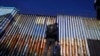 FILE - A migrant waits of the Mexican side of the border after United States Customs and Border Protection officers detained a couple of migrants crossing the U.S.-Mexico border on the beach, in Tijuana, Mexico, Jan. 26, 2022.