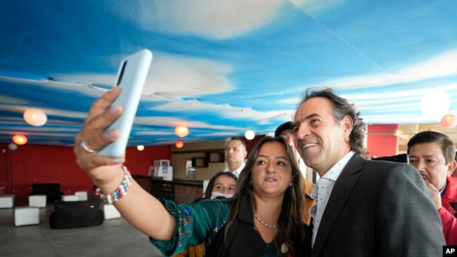 El candidato a la presidencia de Colombia Federico Gutiérrez, de la coalición Equipo Colombia, posa para una foto con una seguidora durante un acto de campaña en Chia, Colombia, el 16 de mayo de 2022.